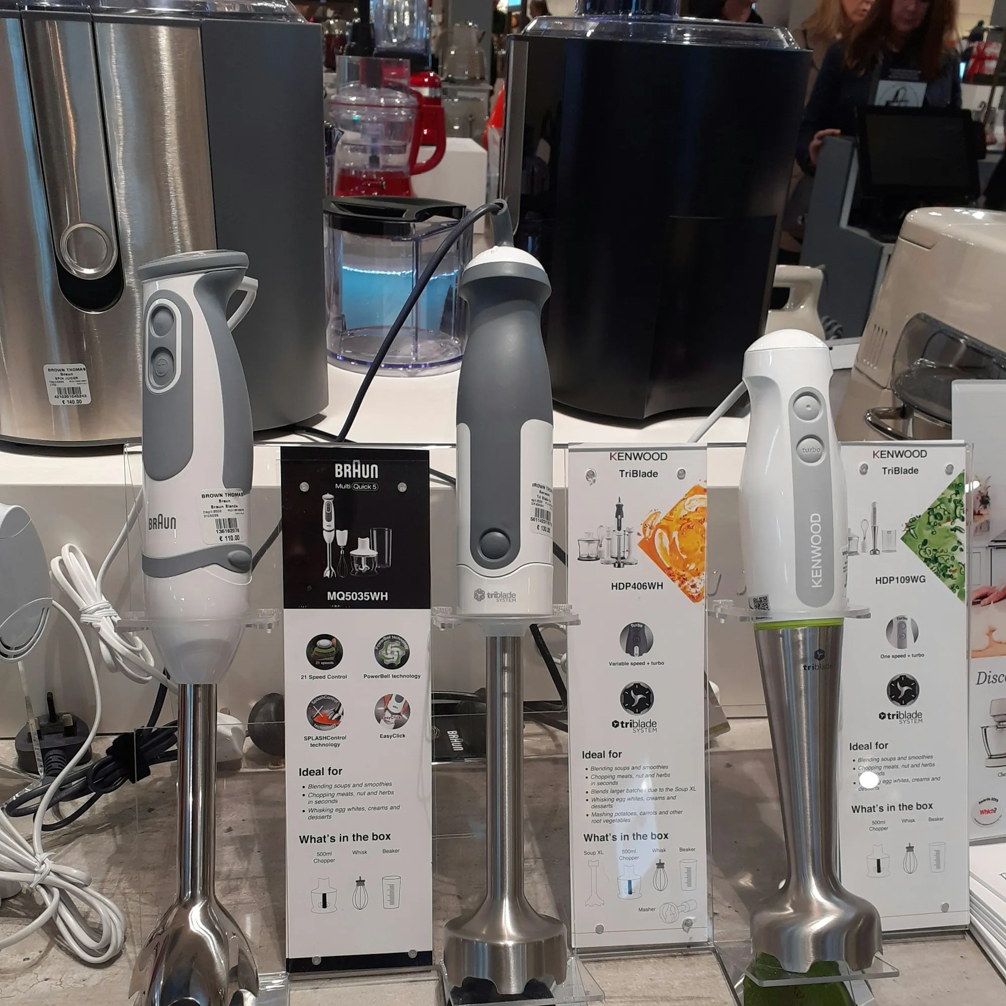 Several stick blenders, including Braun and Kenwood models, on display in a shop