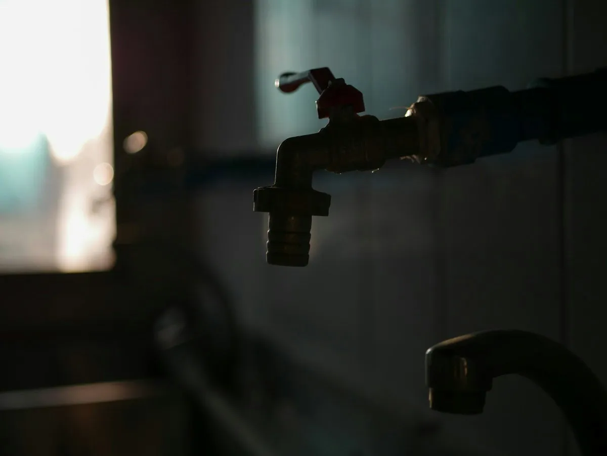 A tap in silhouette against a bright window