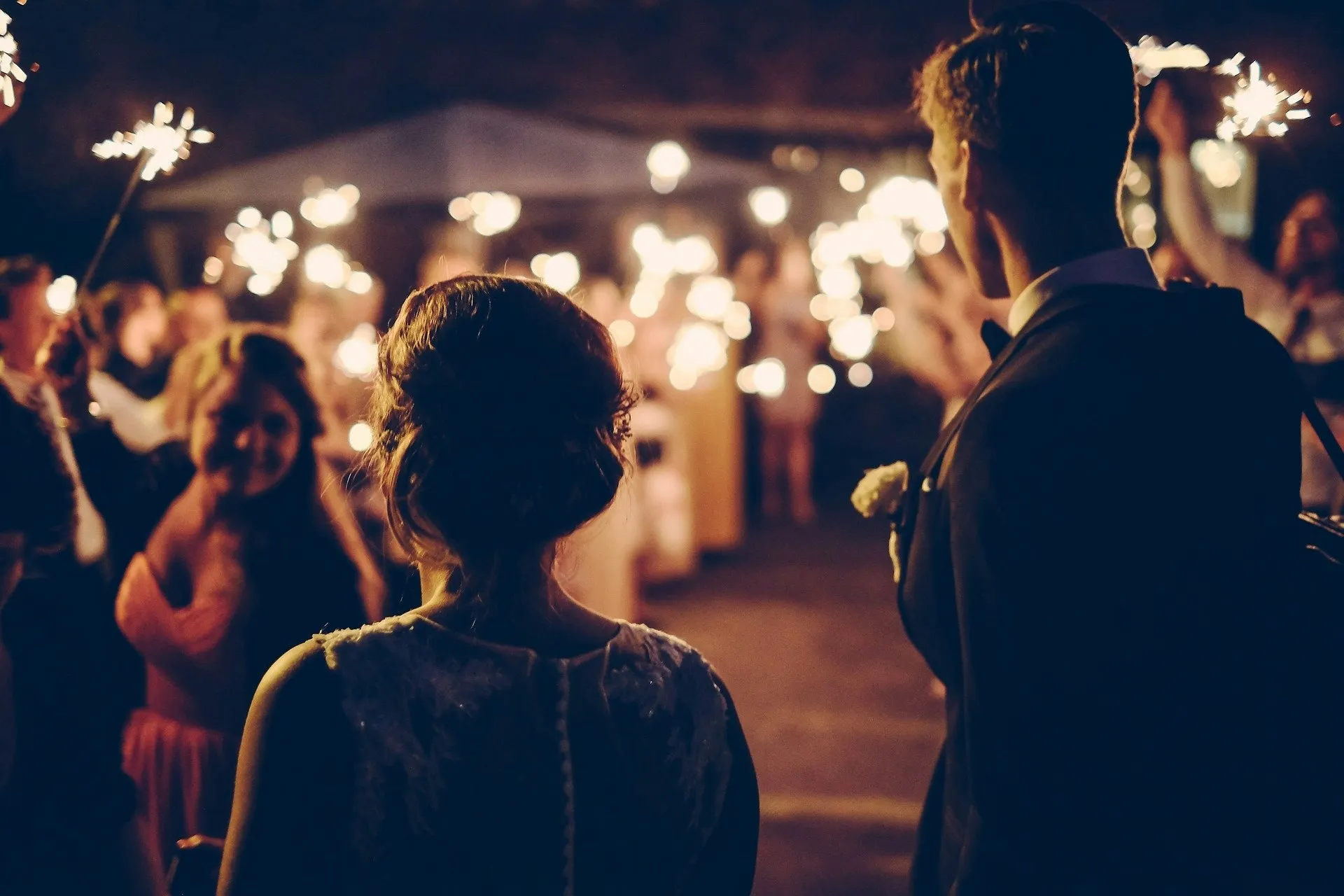 Guests holding sparklers at an evening wedding celebration