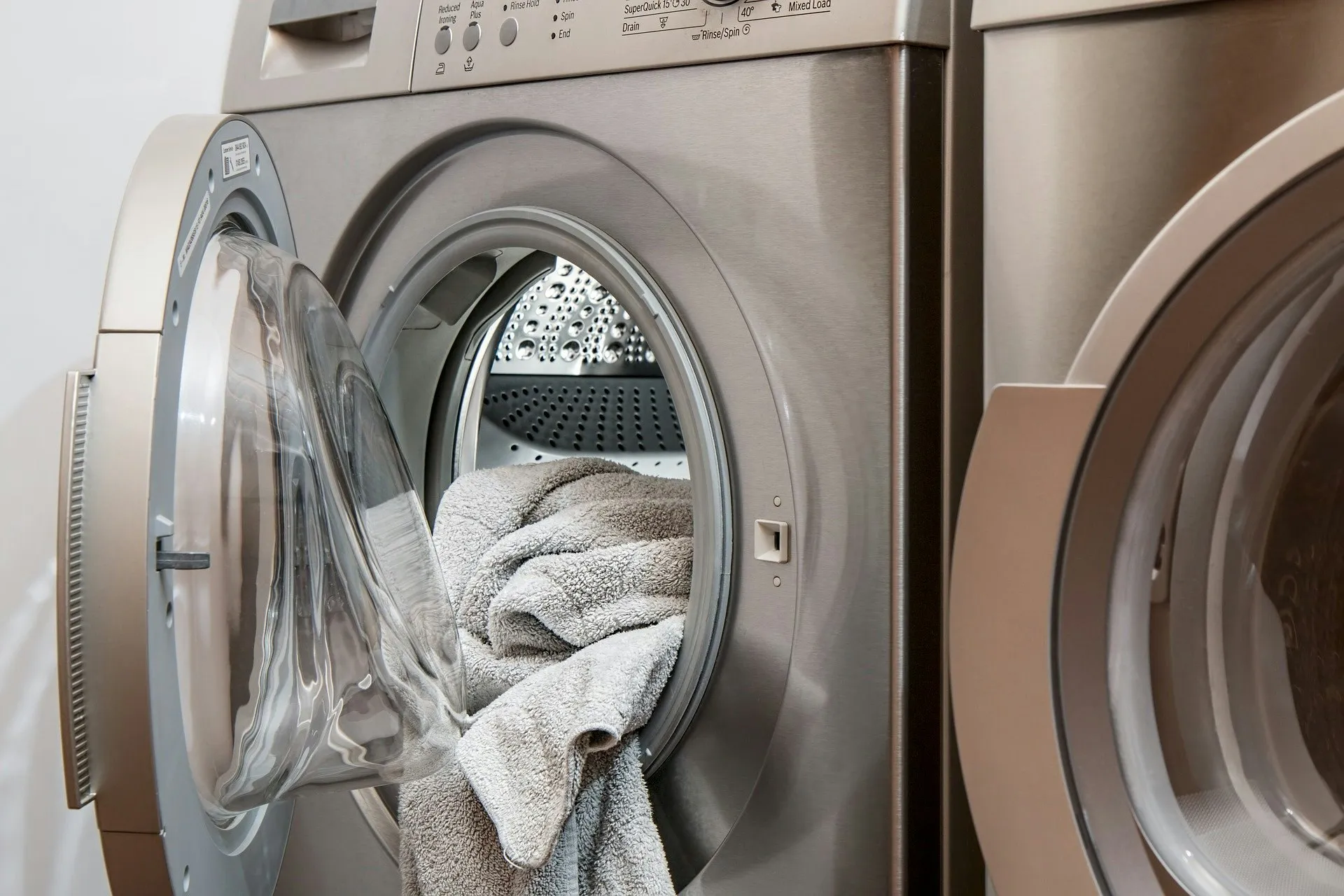 A front-loading washer and dryer with towels in the open drum