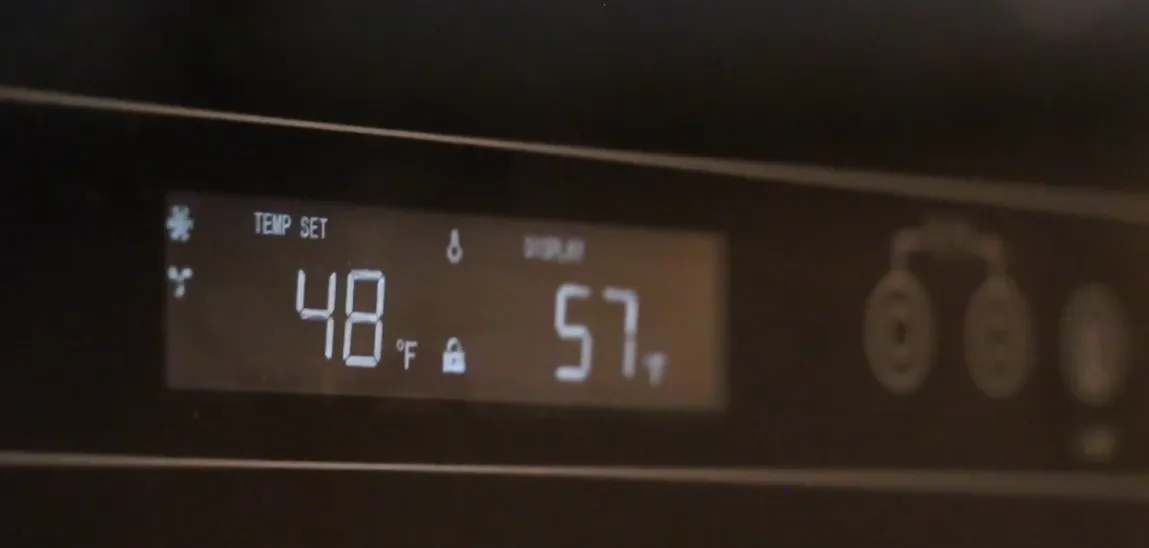 A wine cooler display set to 48°F and showing 57°F
